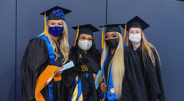 Four female graduates with masks
