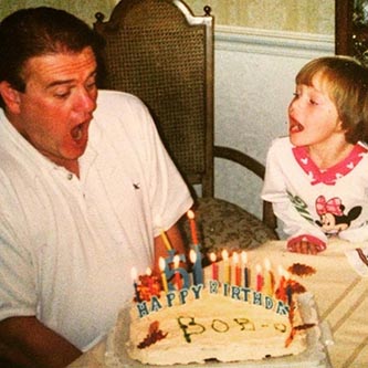 Markie as a child with her dad, blowing out birthday cake candles